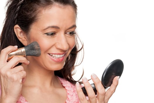 Smiling woman in front of white studio background doing make-up