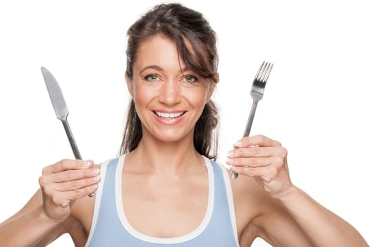 Smiling woman with cutlery against white background