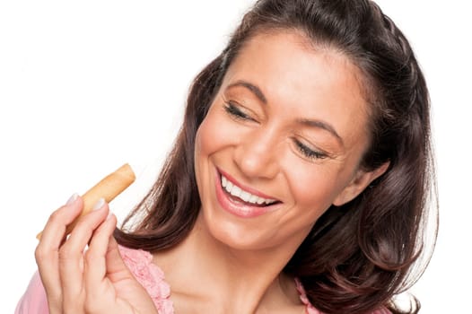 Smiling woman with a biscuit against a white background