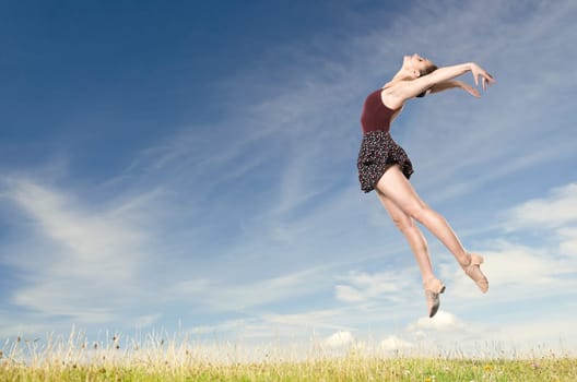 Young woman jumping in front of blue sky