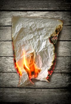 burning paper on wood  background