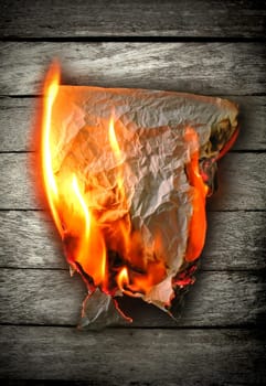 burning paper on wood  background
