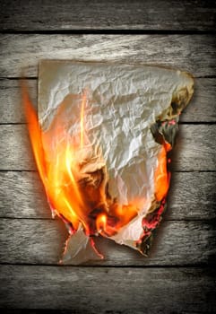 burning paper on wood  background
