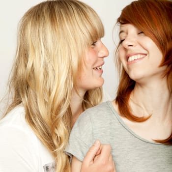 blond and red haired girls are laughing and have fun