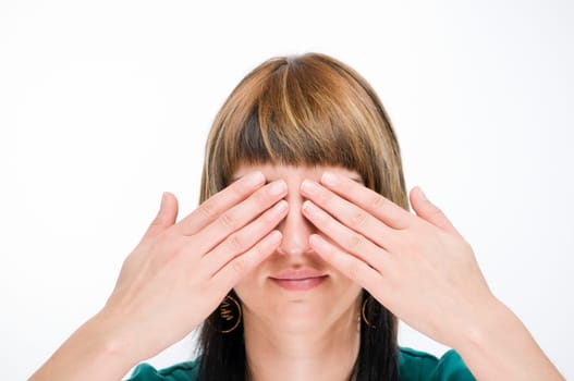 Head and shoulders view of a young woman looking at the camera and covering her eyes  Gesture: "see nothing"""