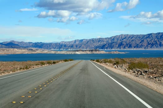 Paved road leads into a lake