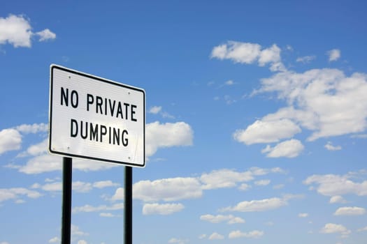 Sign in front of cloudy sunny sky