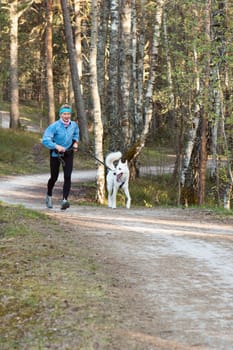 The sports woman with a dog run  in park