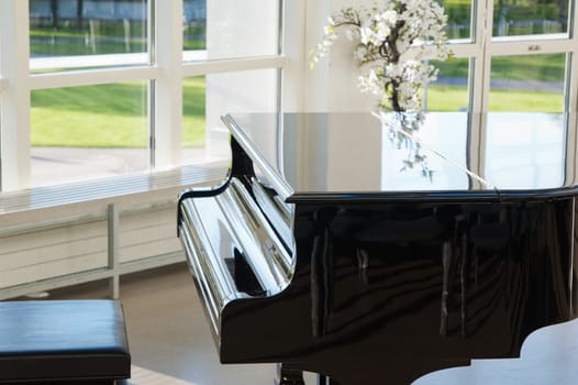 Grand piano in the hall shined by the sun