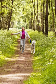 The woman walks with a dog in a wood