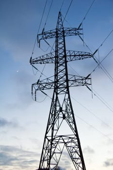 Silhouette of a pillar of electricity transmissions on a background of the evening sky