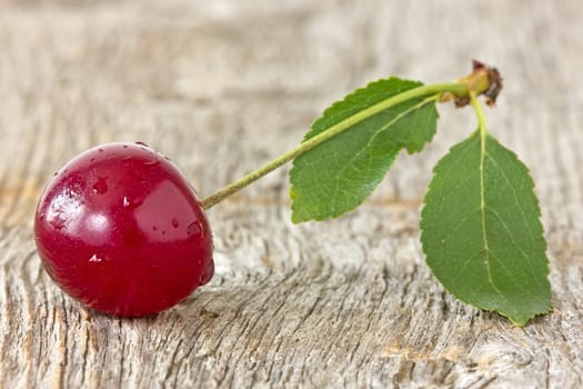 cherry with leaf on the old wooden background