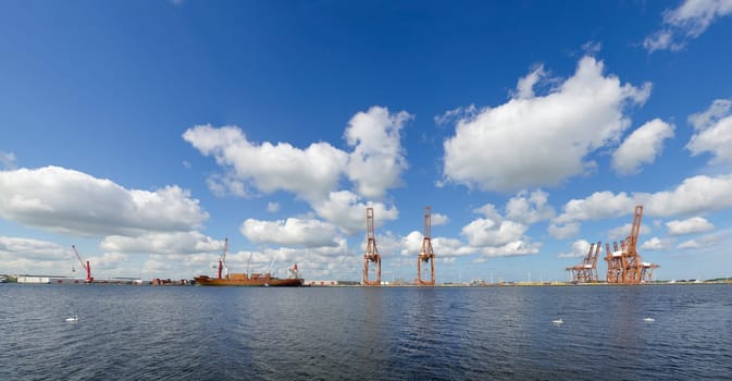 quay in amsterdam harbor with several harbor cranes