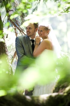 Bride and groom with wedding dress and suit in nature