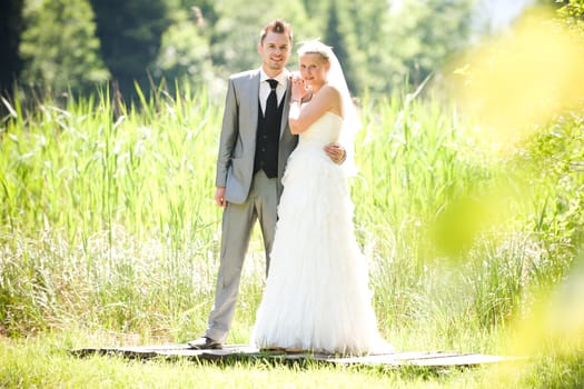 Bride and groom with wedding dress and suit in nature