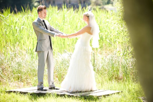 Bride and groom with wedding dress and suit in nature