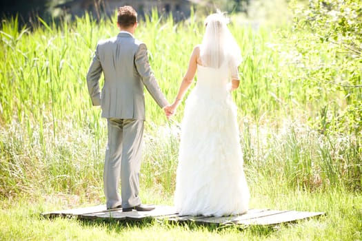 Bride and groom with wedding dress and suit in nature