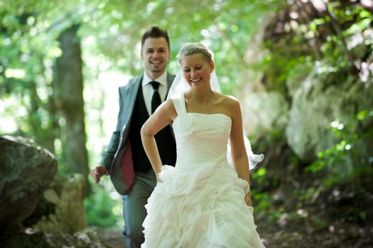 Bride and groom with wedding dress and suit in nature