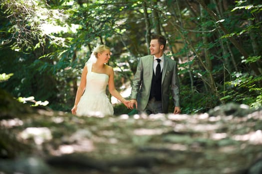 Bride and groom with wedding dress and suit in nature