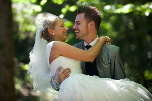 Bride and groom with wedding dress and suit in nature
