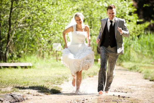 Bride and groom with wedding dress and suit in nature