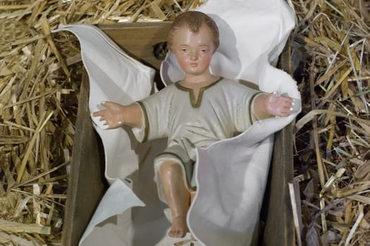 Baby Jesus laying in a cradle Christmas Creche