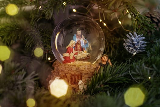 Scene of the nativity of Jesus Christ in a glass ball on a Christmas tree