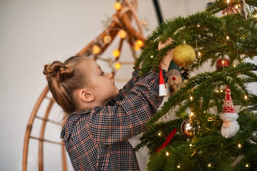 A girl decorates a Christmas tree