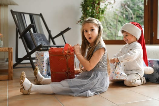 Brother and sister unwrapping christmas presents