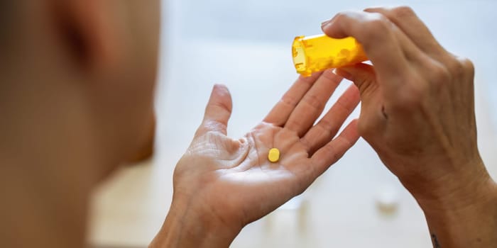 Caucasian woman sitting on the sofa and taking prescription pills prescribed.