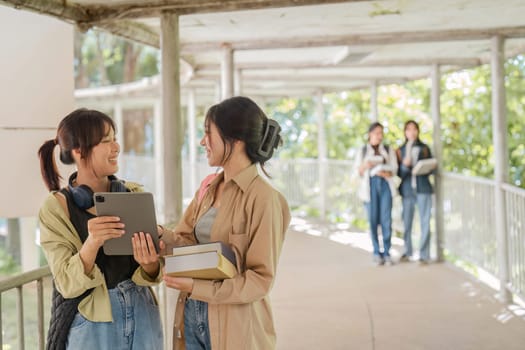 university students using a digital tablet while walking to next class.