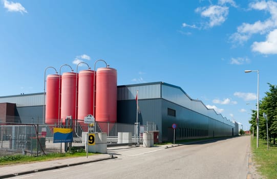 four industrial red silos belonging to a cement factory