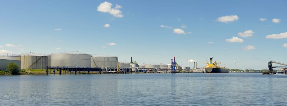 panoramic view of tanker and oil storage tanks in amsterdam harbor