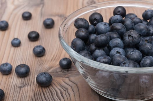 Glass Bowl of Ripe Blueberries on Wooden Table