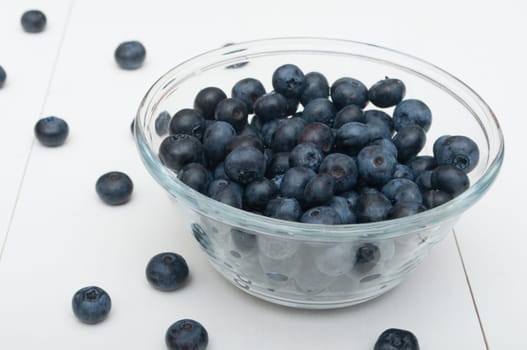 Glass Bowl of Ripe Blueberries on White Wooden Table