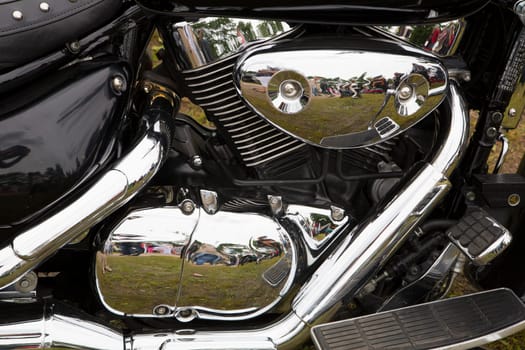 Bike chromed powerful motor are reflecting people silhouettes