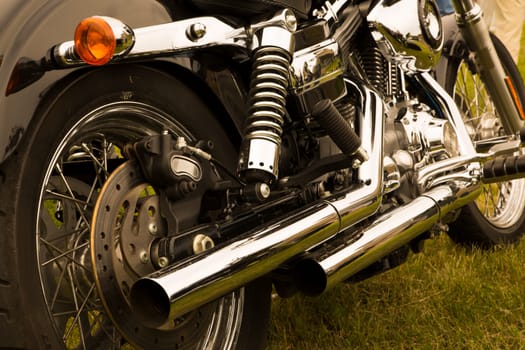 Bike chromed bended pipes are reflecting sun light