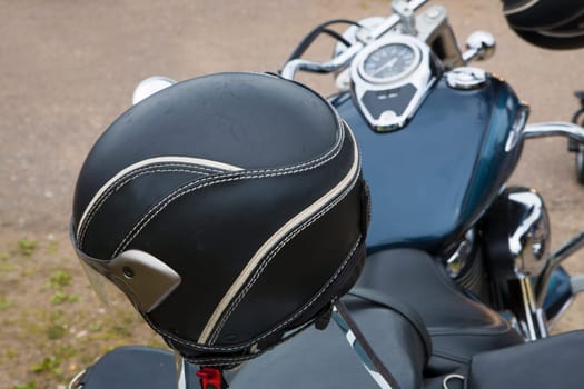 Black round bike helmet on leathered bike seat