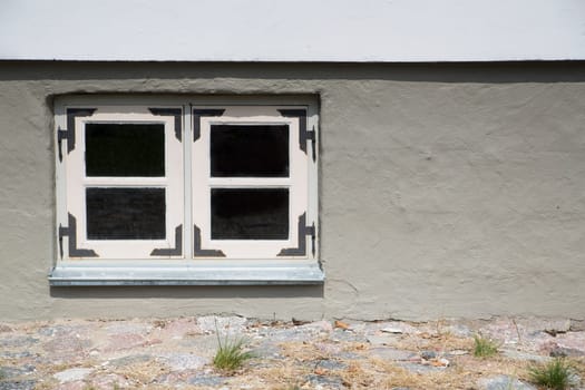 Stony house with filled wall and white window
