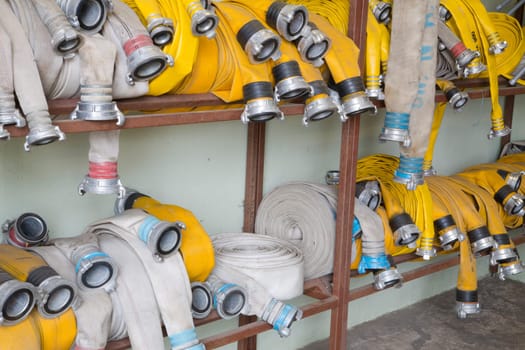 Yellow firehose are hanging on warehouse steel shelfs