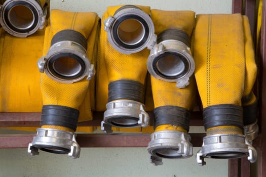 Zoomed yellow firehose are hanging on warehouse  shelfs