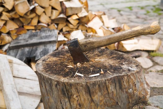 Rusty and used axe in wide old stump