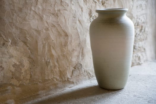Hand maded and smoothed vase in room corner