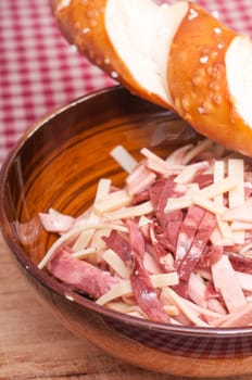 Sausage salad and pretzel stick on a checkered tablecloth