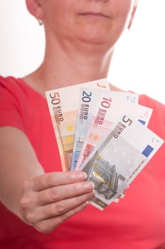 Woman holding several euro bills with her hand in front