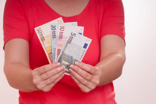 Two female hands holding a bundle of euro bills