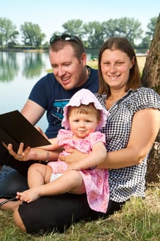 Young guy and girl with books on the nature near lake