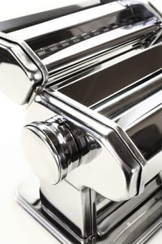 A detail of a pasta machine against a white background