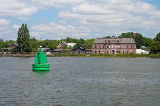 Green navigational buoy with solar panel in the Dutch North Sea Canal