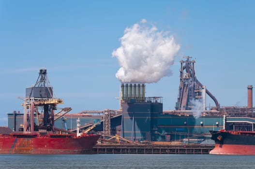 ship unloading in front of a large steel factory in IJmuiden, Netherlands
